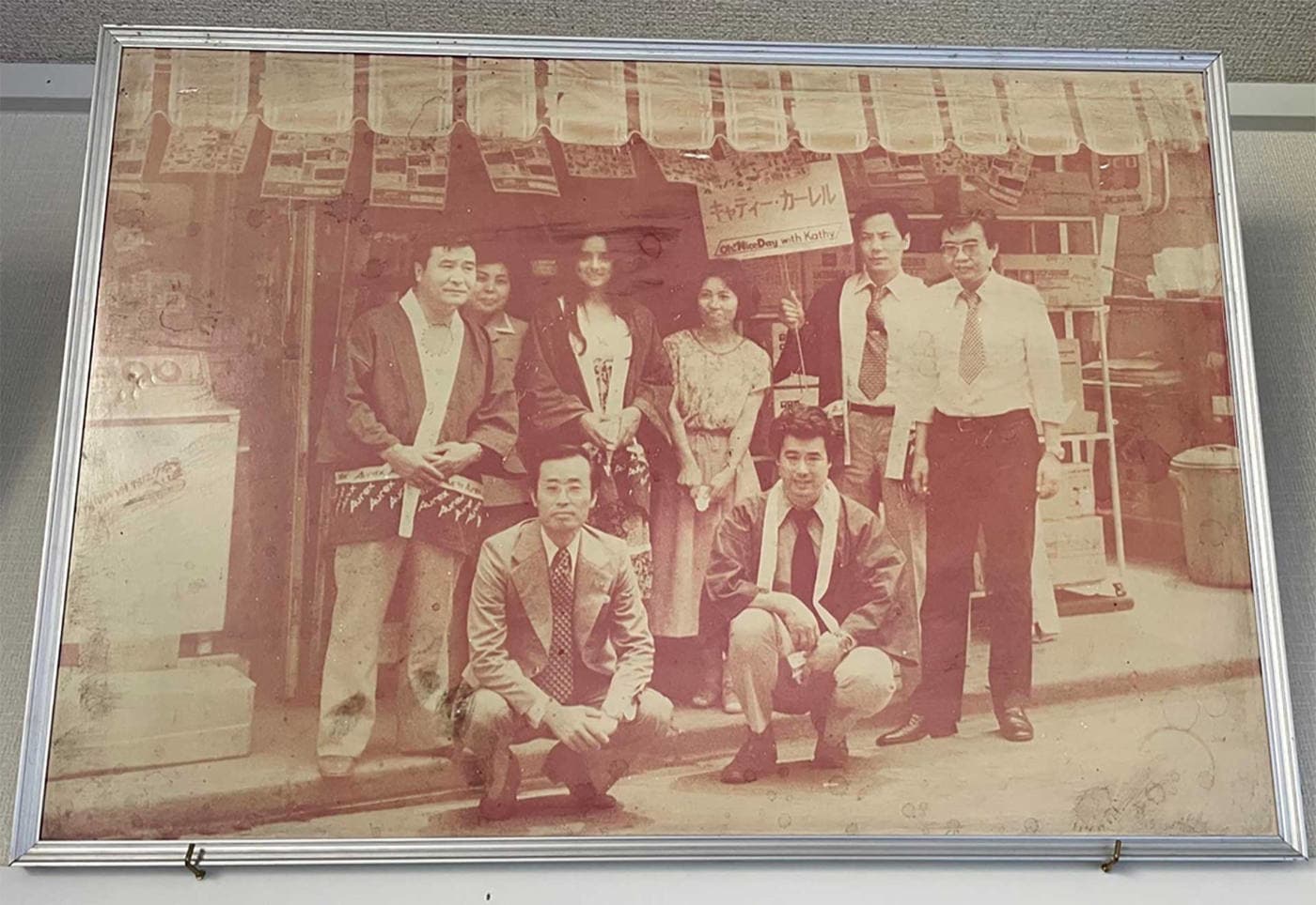 創業当時の店舗の外で従業員が集合している