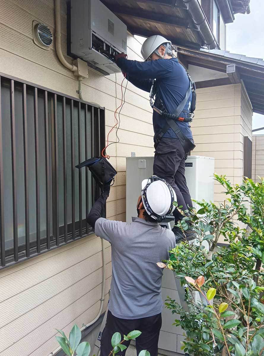 太陽光発電システムの点検を行う作業員